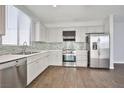 Bright, modern kitchen featuring stainless steel appliances, tile backsplash, and updated countertops at 5575 Cresent Valley St, Las Vegas, NV 89148