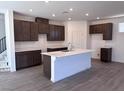Modern kitchen with dark cabinets, white countertops, a central island, and stainless steel faucet at 6616 Bowery St, Las Vegas, NV 89148