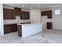 Unfinished kitchen with dark wood cabinetry, a center island and white countertops at 6616 Bowery St, Las Vegas, NV 89148