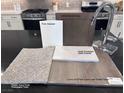 Sample of interior finishes, featuring carpet, vinyl plank, countertops, and cabinet colors at 6616 Bowery St, Las Vegas, NV 89148