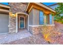 Close-up of front entrance with stone veneer and a blue front door with decorative sidelight at 7106 Stanley Frederick St, Las Vegas, NV 89166