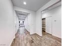 Bright hallway with wood-look tile flooring, white walls, and storage closet at 7106 Stanley Frederick St, Las Vegas, NV 89166