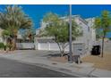 Two-story home featuring desert landscaping, a three-car garage, and a street view at 7650 Hartwell Dr, Las Vegas, NV 89123