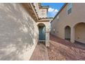 Inviting entryway with a teal door, brick pathway, and decorative wall accent at 7970 Calito St, Las Vegas, NV 89166