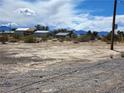 Exterior view of a residence, showing desert landscaping under a partly cloudy sky and distant mountain views at 81 W Mesquite Ave, Pahrump, NV 89060