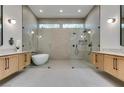 Sleek bathroom features a soaking tub and glass-enclosed shower between two modern vanities at 8649 Robinson Ridge Dr, Las Vegas, NV 89117