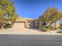 Attractive single-story home with a three-car garage, landscaped front yard, and a welcoming curb appeal at 10446 Abbotsbury Dr, Las Vegas, NV 89135