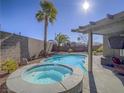 Sparkling backyard pool and spa, perfect for outdoor entertaining and relaxation under the sunny sky at 10446 Abbotsbury Dr, Las Vegas, NV 89135