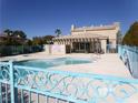 A community pool area with a decorative fence and covered seating area, perfect for relaxation at 1401 N Michael Way # 239, Las Vegas, NV 89108