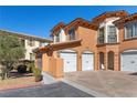 Inviting multi-level townhome featuring a private 2-car garage and beautiful terracotta-toned stucco at 16 Via Visione # 101, Henderson, NV 89011