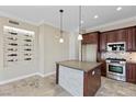 Well-lit kitchen featuring a central island, dark wood cabinets, and stainless steel appliances at 16 Via Visione # 101, Henderson, NV 89011