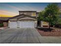 Two-story home with a three-car garage, neutral paint, and landscaped front yard at 1754 Quiver Point Ave, Henderson, NV 89012