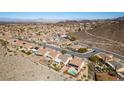 An aerial view showcases a desert neighborhood surrounded by mountain with sidewalks and mature landscaping at 2035 King Mesa Dr, Henderson, NV 89012