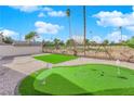 This backyard features an immaculate putting green and wrought iron fence overlooking a golf course at 2160 Pueblo Cir, Las Vegas, NV 89169