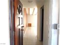 Hallway with tiled floor, wood door, and bright light fixture at 2313 E Mcwilliams Ave, Las Vegas, NV 89101