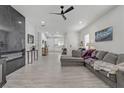 Spacious living room with gray sofa, modern decor, and view of a modern, well-lit kitchen at 2728 Goldcreek St, Henderson, NV 89052