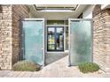 Covered entry with decorative glass panels, leading to a modern home with stone accents at 32 Hunting Horn Dr, Las Vegas, NV 89135