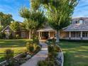 Beautiful traditional home featuring mature trees, a walkway, and manicured landscaping at 330 Rancho Cir, Las Vegas, NV 89107