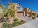 Charming two-story home features a desert landscape, stone accents, and a spacious driveway leading to a two-car garage at 4138 Bayley Skye Ave, Las Vegas, NV 89141