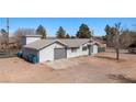 View of the single-story gray home with a metal roof, attached garage, and a spacious yard at 432 Bonelli Ave, Overton, NV 89040