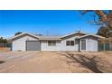 View of gray home featuring a metal roof, attached garage, fenced yard, and covered porch at 432 Bonelli Ave, Overton, NV 89040