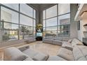 Spacious living room with floor-to-ceiling windows offering city views and modern furnishings at 4515 Dean Martin Dr # 200, Las Vegas, NV 89103