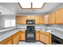 Compact kitchen featuring light wood cabinets, a gas range, and neutral countertops under bright lighting at 4655 Gold Dust Ave # 139, Las Vegas, NV 89120