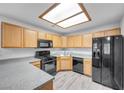 Well-lit kitchen featuring matching black appliances and neutral countertops with light wood cabinetry at 4655 Gold Dust Ave # 139, Las Vegas, NV 89120