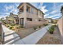 A modern home with a sidewalk, rock landscaping, and a backyard patio at 500 Pear Lake St, Las Vegas, NV 89138