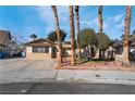 Single-story home featuring desert landscaping and mature palm trees in the front yard at 5111 Rudy Ln, Las Vegas, NV 89120