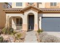 Close-up of the home's entrance featuring a covered porch and two-car garage at 5596 Danforth Ave, Las Vegas, NV 89141