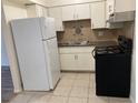 Traditional kitchen featuring white cabinets, black appliances, and mosaic backsplash at 565 S Royal Crest Cir # 15, Las Vegas, NV 89169