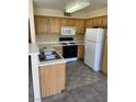 Functional kitchen featuring wooden cabinets, white appliances, and ample counter space at 5710 E Tropicana Ave # 2047, Las Vegas, NV 89122