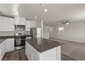 Open concept kitchen with white cabinets, gray countertops, stainless appliances, and seamless flow to living area at 6257 Blood Lily Ave, Las Vegas, NV 89122