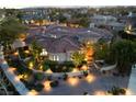 Beautiful home with an aerial view showing the red tiled roof and lush landscaping illuminated at twilight at 9825 Glenrock Dr, Las Vegas, NV 89134