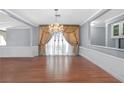 Open-concept living room featuring a decorative chandelier, hardwood floors and light gray walls at 1301 E St Louis Ave # C, Las Vegas, NV 89104