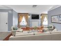 Bright living room with fireplace, large windows with ornate drapes, and hardwood flooring at 1301 E St Louis Ave # C, Las Vegas, NV 89104