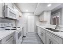 Modern kitchen featuring white appliances, quartz countertops, grey cabinets and wood-look laminate flooring at 220 Mission Catalina Ln # 202, Las Vegas, NV 89107