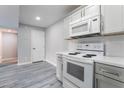 Modern kitchen featuring white appliances, quartz countertops, grey cabinets and wood-look laminate flooring at 220 Mission Catalina Ln # 202, Las Vegas, NV 89107