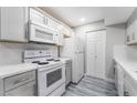 Modern kitchen featuring white appliances, quartz countertops, grey cabinets and wood-look laminate flooring at 220 Mission Catalina Ln # 202, Las Vegas, NV 89107