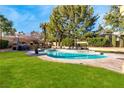 The refreshing pool and spa are surrounded by lush landscaping and patio space at 229 Drysdale Cir, Henderson, NV 89074