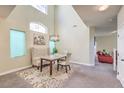 Bright dining area with high ceilings, chandelier, and views into the living room at 2865 Vigilante Ct, North Las Vegas, NV 89081