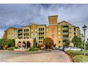 Mediterranean-style condo building with arched entryway, balconies, colorful facade and neatly landscaped grounds at 30 Strada Di Villaggio # 143, Henderson, NV 89011