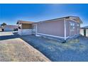 Exterior angle shot of a single-story home highlighting the side entrance and gravel driveway at 3581 W Dyer Rd, Pahrump, NV 89048