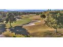 Scenic aerial view of a well-maintained golf course, with manicured greens, sand traps, and mature trees at 4961 Tierra Del Sol Dr, Las Vegas, NV 89113