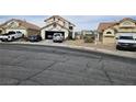 Front exterior of a two-story house with neutral stucco, tile roof, and an attached garage at 6624 Socorro Dr, Las Vegas, NV 89108