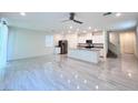 Open-concept living room with modern tile flooring, stainless steel appliances, and a large kitchen island at 7708 Mojave Wind Ave, Las Vegas, NV 89113
