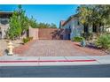 View of the brick driveway with a decorative wooden gate and an RV parked alongside the property at 8604 Amber Autumn St, Las Vegas, NV 89131