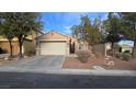 Charming single-story home with a two-car garage, neutral stucco, and well-maintained desert landscaping at 8824 Martin Downs Pl, Las Vegas, NV 89131