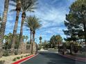 Gated community entrance surrounded by palm trees and well-maintained landscaping at 11027 Dornoch Castle St, Las Vegas, NV 89141